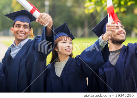 happy students in mortar boards with diplomas 29343290