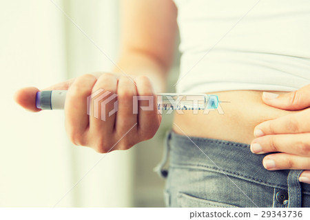 close up of hands making injection by insulin pen 29343736