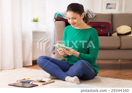 happy woman with money and travel map at home 29344160