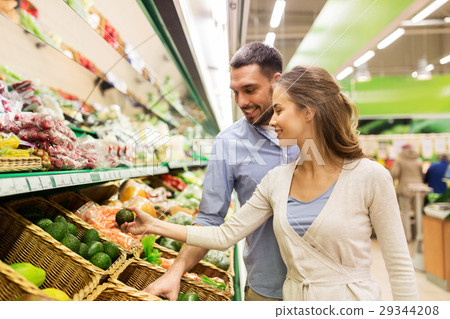happy couple buying avocado at grocery store happy couple buying avocado at grocery store 29344208