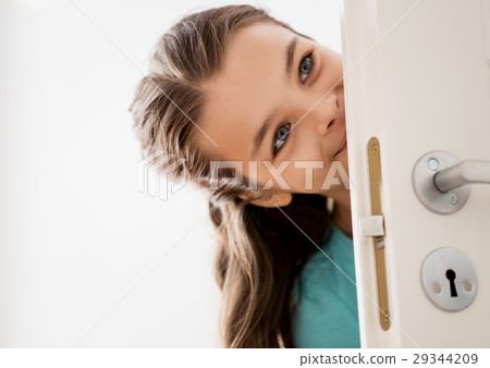 happy smiling beautiful girl behind door at home happy smiling beautiful girl behind door at home 29344209