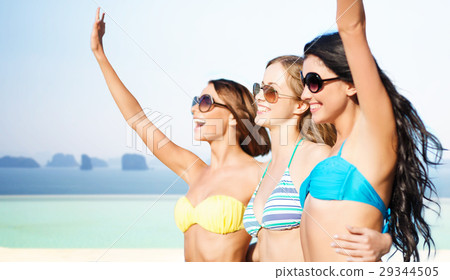 happy young women in bikinis on summer beach 29344505