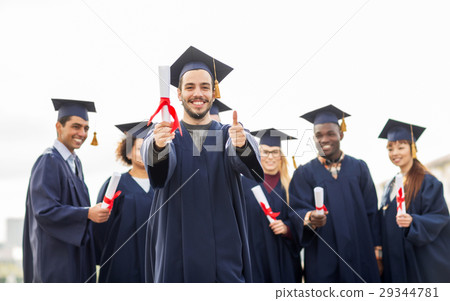 happy students with diplomas showing thumbs up happy students with diplomas showing thumbs up 29344781