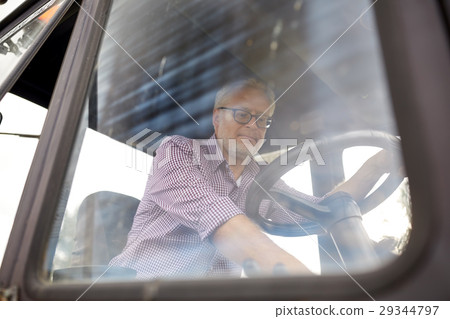 senior man driving tractor at farm senior man driving tractor at farm 29344797