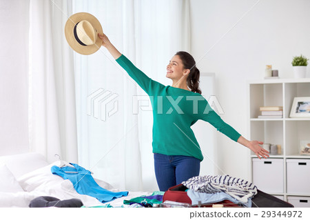 woman packing travel bag at home or hotel room woman packing travel bag at home or hotel room 29344972