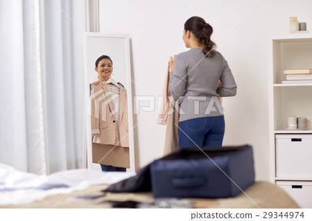 woman packing travel bag at home or hotel room woman packing travel bag at home or hotel room 29344974