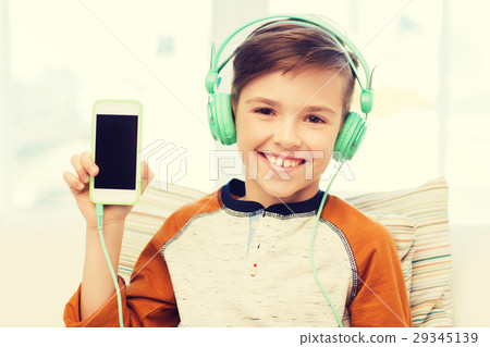 happy boy with smartphone and headphones at home 29345139