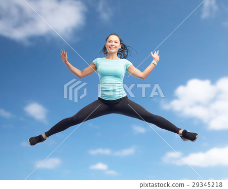 happy smiling sporty young woman jumping in air happy smiling sporty young woman jumping in air 29345218