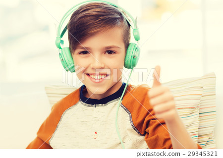 happy boy in headphones showing thumbs up at home happy boy in headphones showing thumbs up at home 29345321
