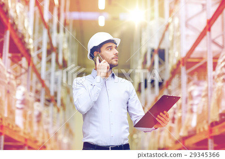 man with clipboard and smartphone at warehouse 29345366