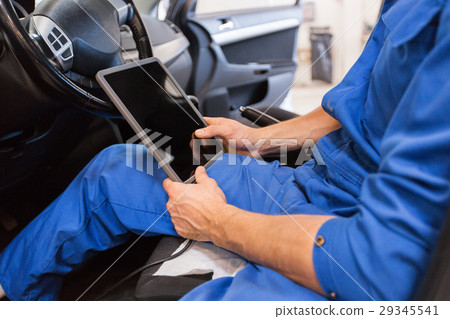 mechanic man with tablet pc making car diagnostic 29345541