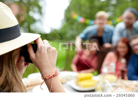 woman photographing friends at summer garden party woman photographing friends at summer garden party 29345860