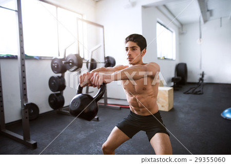 Young fit hispanic man in gym doing kettlebell Young fit hispanic man in gym doing kettlebell 29355060