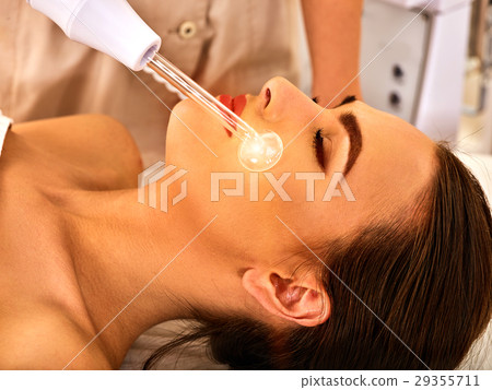 Young woman receiving electric facial massage. Young woman receiving electric facial massage. 29355711