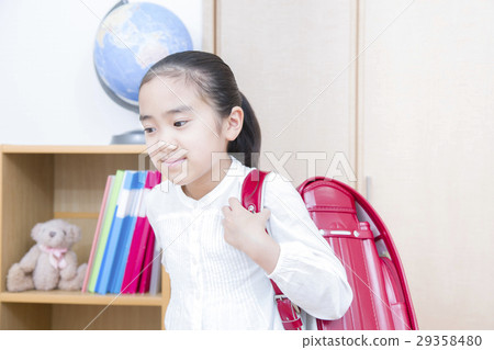 A girl carrying a school bag 29358480