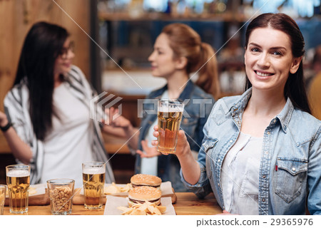 Smiling brunette posing with bocal of beer 29365976