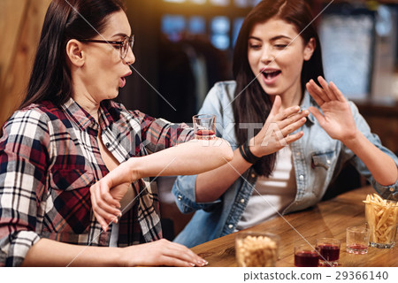Attentive brunette putting glass on her elbow Attentive brunette putting glass on her elbow 29366140