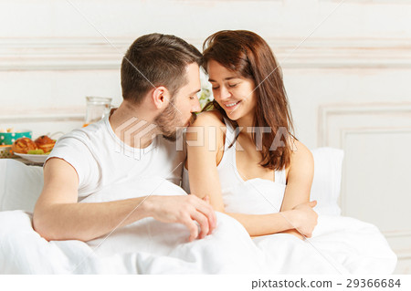 Young adult heterosexual couple lying on bed in Young adult heterosexual couple lying on bed in 29366684