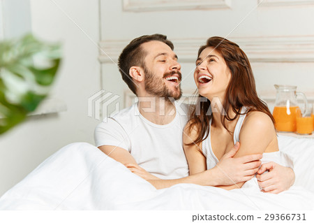 Young adult heterosexual couple lying on bed in Young adult heterosexual couple lying on bed in 29366731