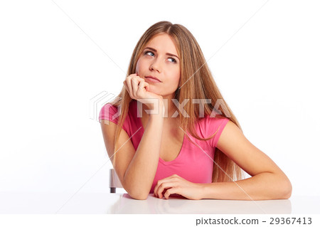 Pensive woman behind a table 29367413