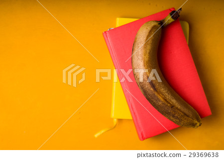 One banana on notepads on a bright background One banana on notepads on a bright background 29369638
