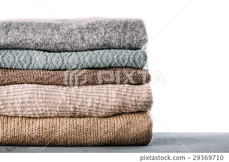 Pile of knitted winter clothes on table 29369710