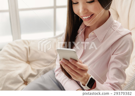 Outgoing young female looking at mobile 29370382