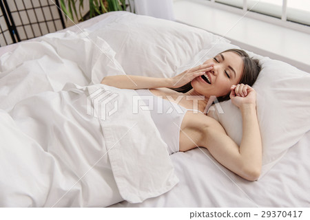 Happy woman lying in bed Happy woman lying in bed 29370417