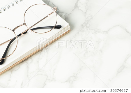 Eyeglasses on book on marble luxury table with copy space 29374627