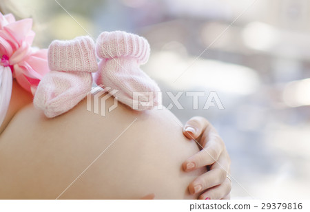 pregnant woman's belly with booties on it 29379816