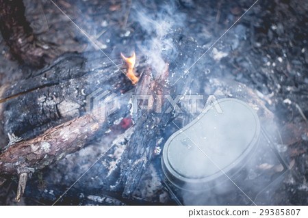 Cooking army pot on bonfire with firewood 29385807