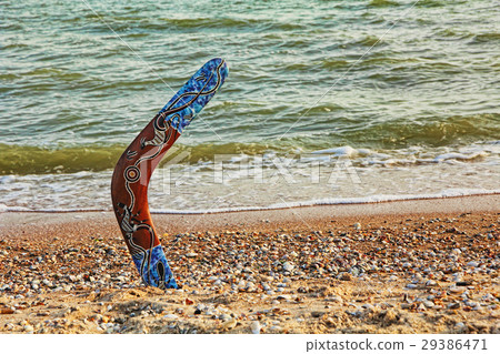 Boomerang on sandy coastline near sea surf. 29386471