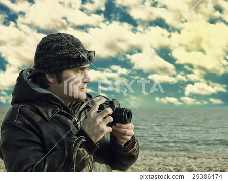 Photographer with vintage photocamera on sea beach 29386474