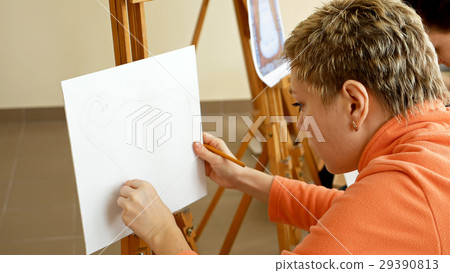 Female artist draws a pencil sketch in art studio Female artist draws a pencil sketch in art studio 29390813