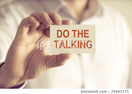 Businessman holding DO THE TALKING message card Businessman holding DO THE TALKING message card 29403171