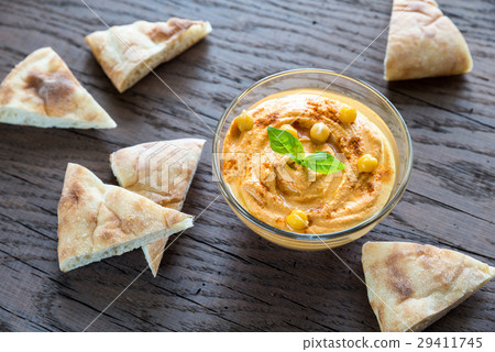 A bowl of hummus with pita slices A bowl of hummus with pita slices 29411745