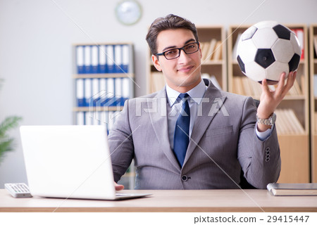Businessman with football ball in office Businessman with football ball in office 29415447
