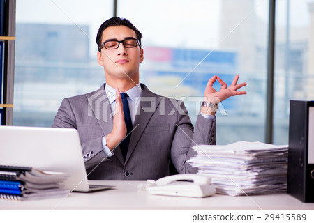 Businessman meditating in the office 29415589