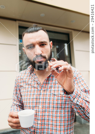 Cocky hipster with coffee and cigarette portrait 29416421