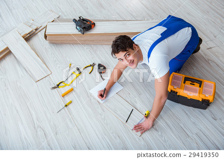 Repairman laying laminate flooring at home 29419350