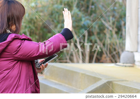 OL holiday shake a hand waving while holding a smartphone 29420664