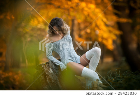 sensual girl with long legs sitting on a stump sensual girl with long legs sitting on a stump 29423830