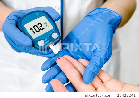 Doctor woman measuring glucose level Doctor woman measuring glucose level 29426241