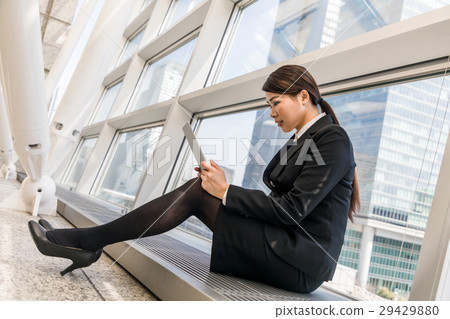 坐和觀看片劑個人計算機的婦女 坐和觀看片劑個人計算機的婦女 29429880