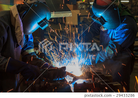 Workers are welding car part with protective mask 29433286