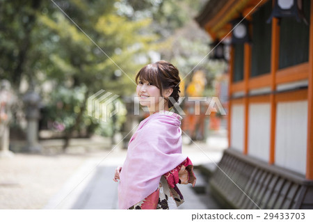 一個年輕的女子，在京都府東山區祗園鎮的八坂神社區內和服走在和服的笑臉 29433703