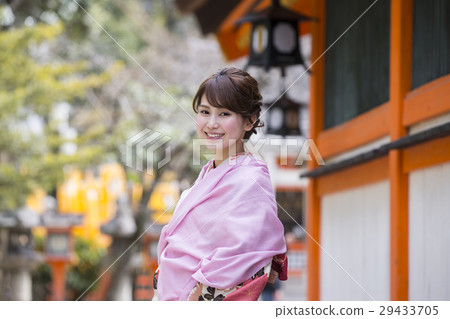 一個年輕的女子，在京都府東山區祗園鎮的八坂神社區內和服走在和服的笑臉 29433705