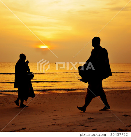 Silhouette of monk walk on the beach Silhouette of monk walk on the beach 29437732