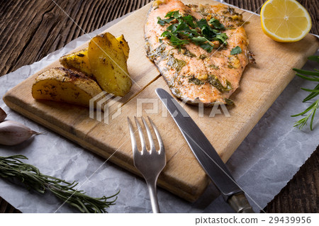 Trout with potateos on wooden board. Trout with potateos on wooden board. 29439956