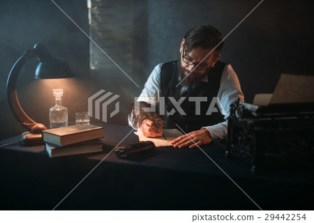 Bearded writer in glasses writes with a feather Bearded writer in glasses writes with a feather 29442254